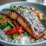 Teriyaki Salmon Bowl served in a rustic bowl, garnished with sesame seeds and fresh green onions for extra flavor.