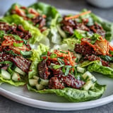Juicy marinated Korean BBQ beef filling crisp lettuce cups with fresh crunchy vegetables.