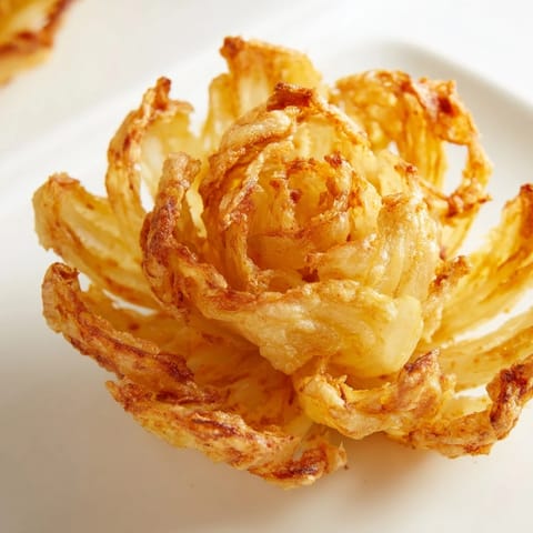 Deep-fried, breaded Onion Petals with a crunchy crust and creamy dip, perfect for game day snacks or party platters.