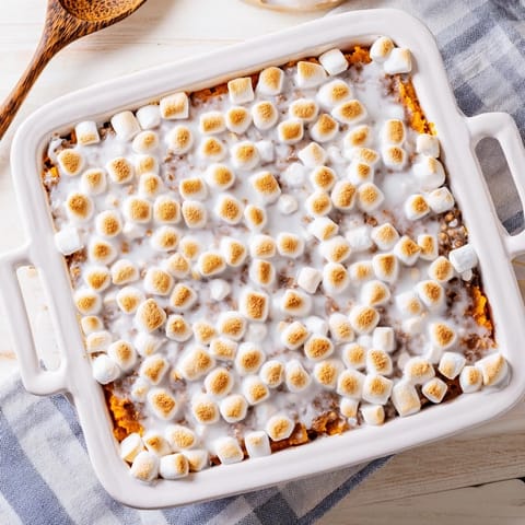 Freshly baked Sweet Potato Casserole with toasted, golden-brown marshmallows bubbling over a creamy sweet potato base.