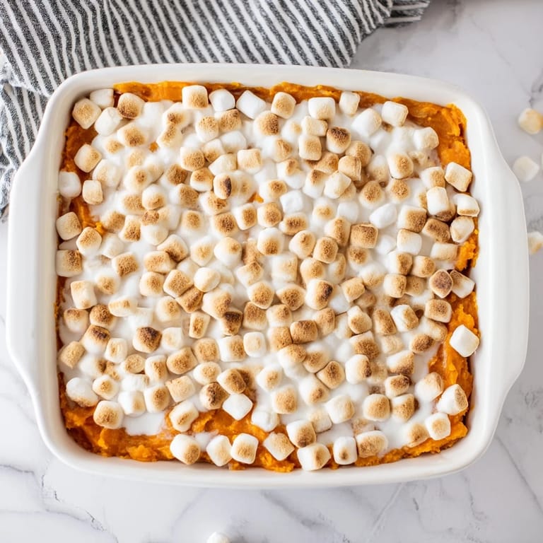 Golden-brown Sweet Potato Casserole with a crunchy pecan streusel topping, served alongside a festive holiday dinner.