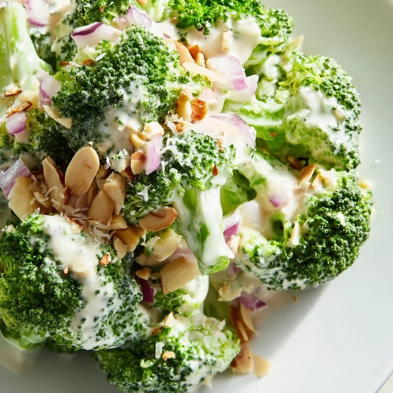A close-up of the chilled Garlic Parmesan Broccoli Salad, showcasing the creamy dressing coating the crisp broccoli and savory Parmesan.