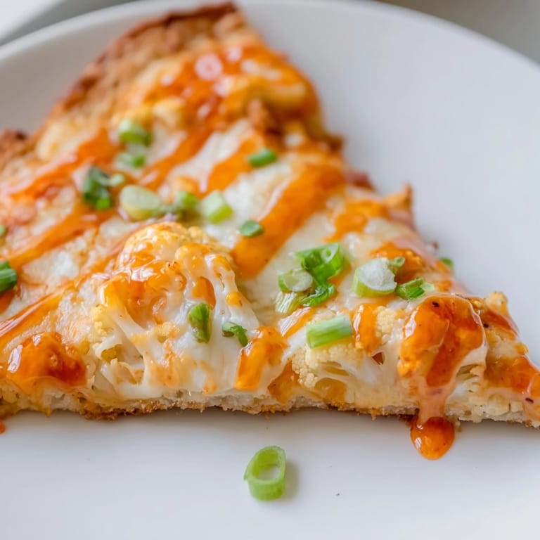 Buffalo Cauliflower Pizza served hot, garnished with green onions and parsley, perfect for a vegetarian dinner.
