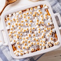 Freshly baked Sweet Potato Casserole with toasted, golden-brown marshmallows bubbling over a creamy sweet potato base.